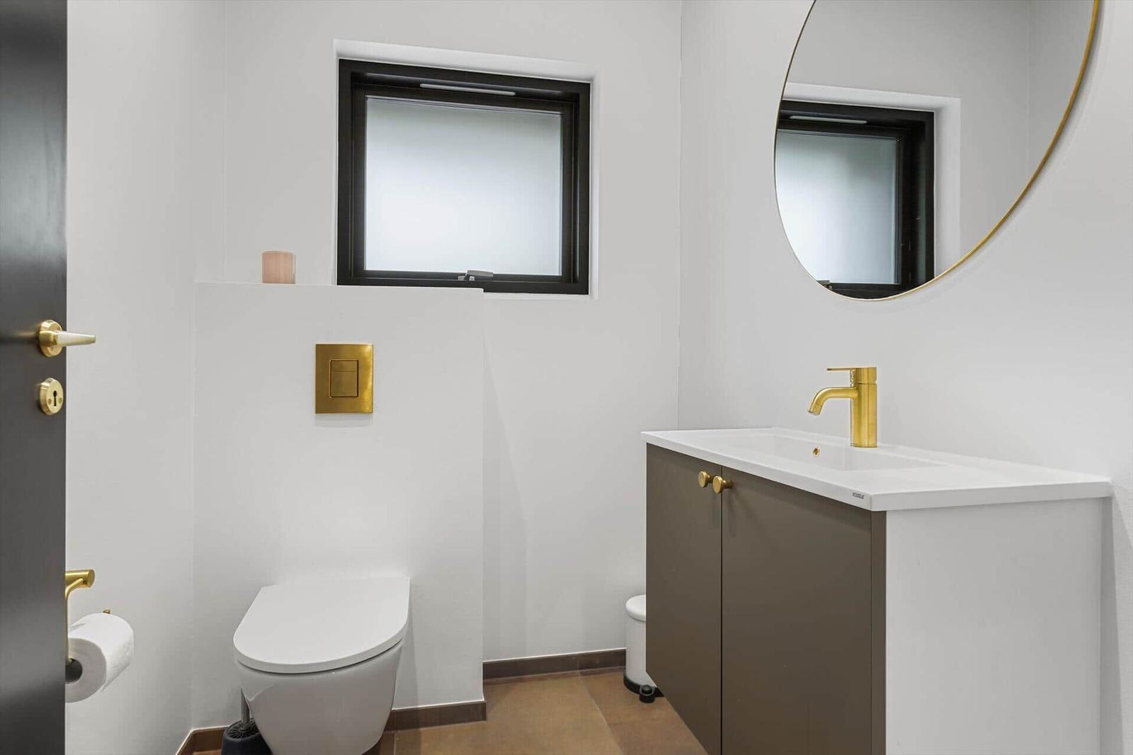 Badezimmer mit Toilette, Waschbecken und Spiegel