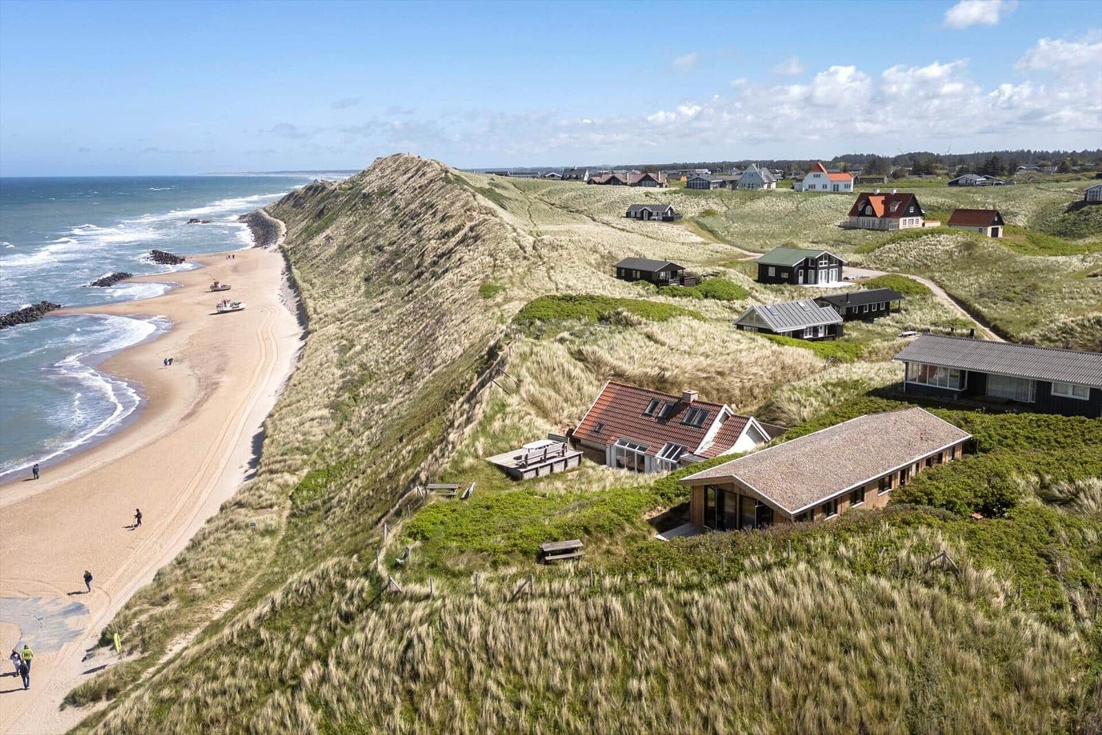 Strandhaus auf Dünen mit Blick aufs Meer und Sandstrand.