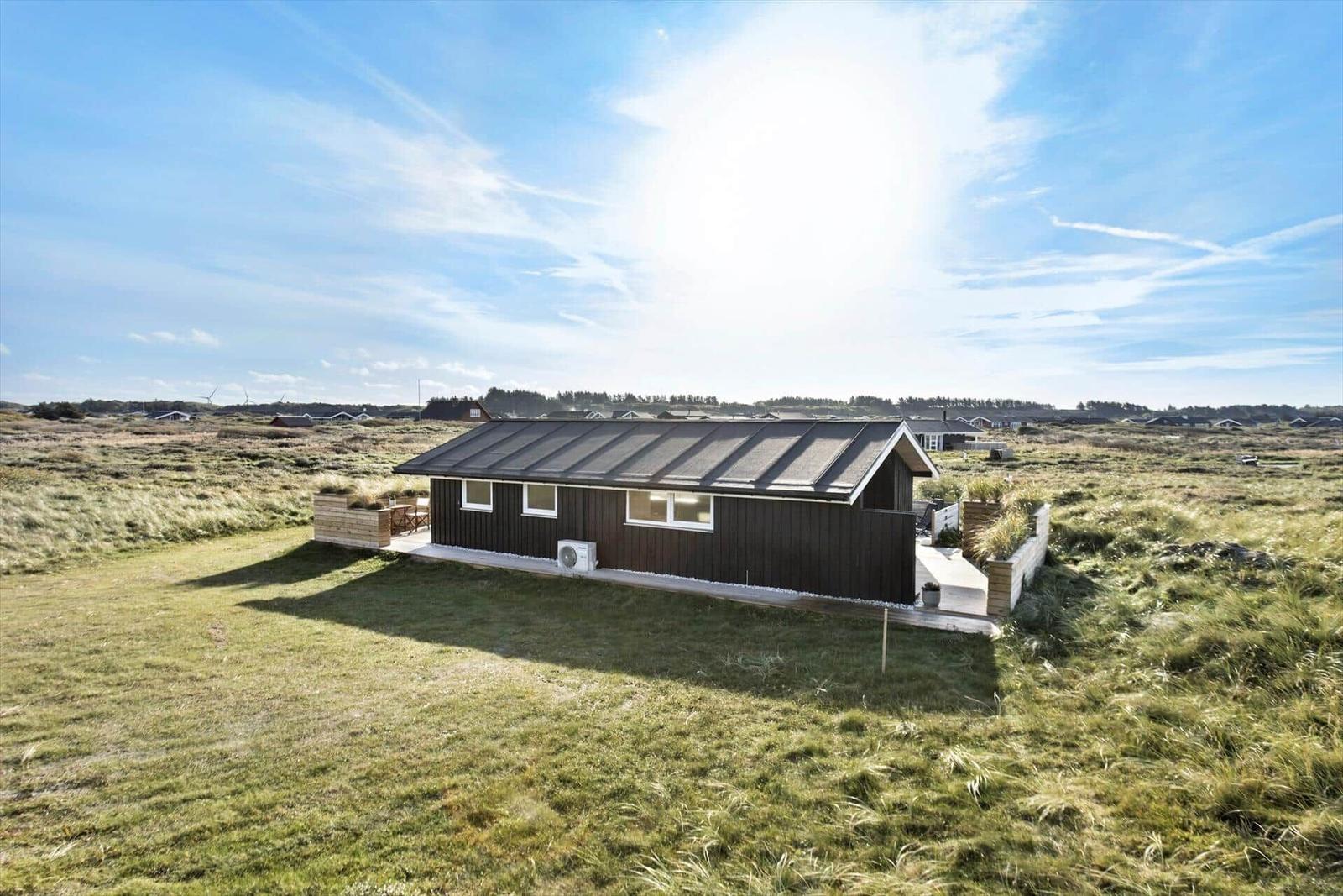 Modern wooden cabin with terrace in green surroundings