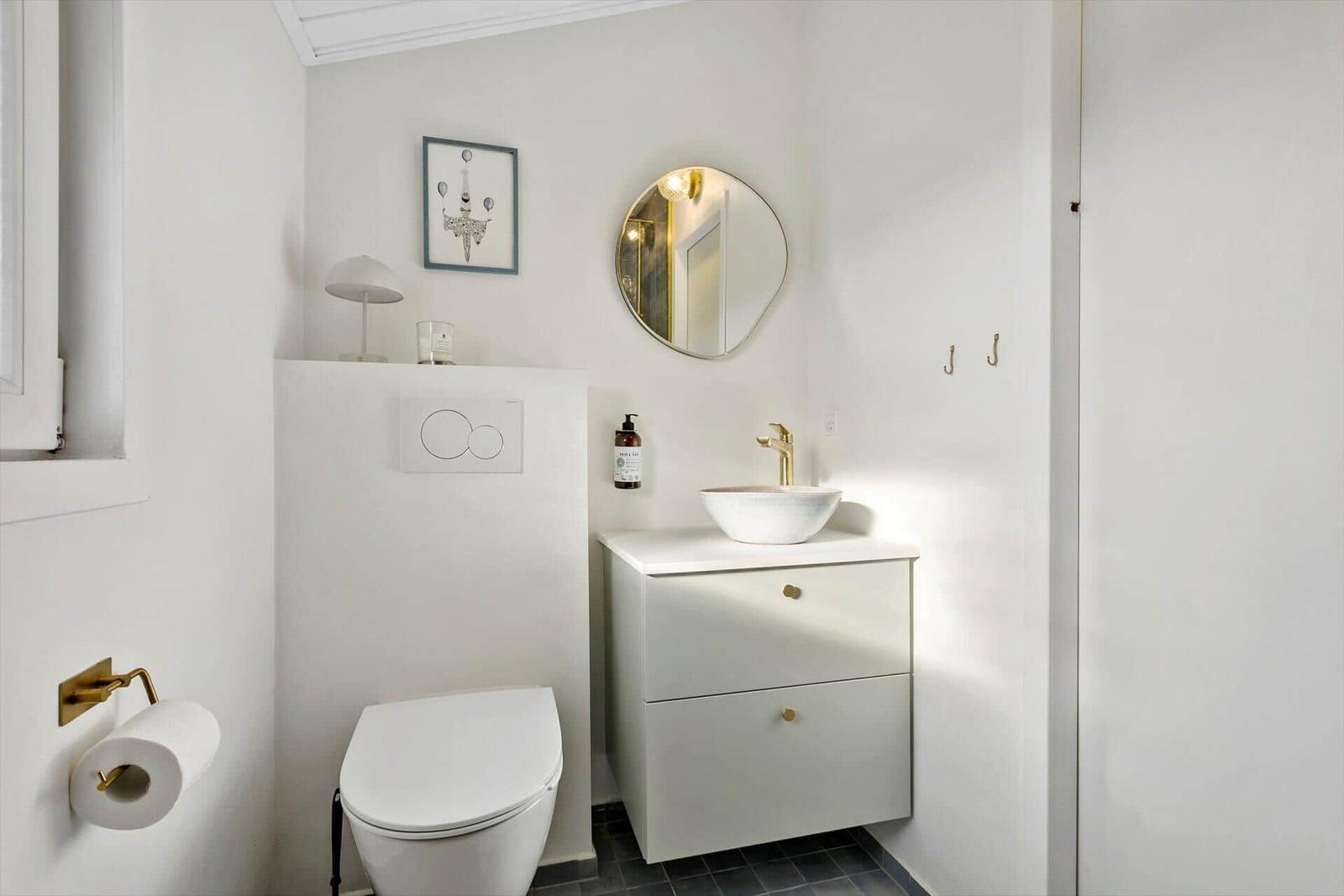 Bathroom with toilet, sink, and mirror.