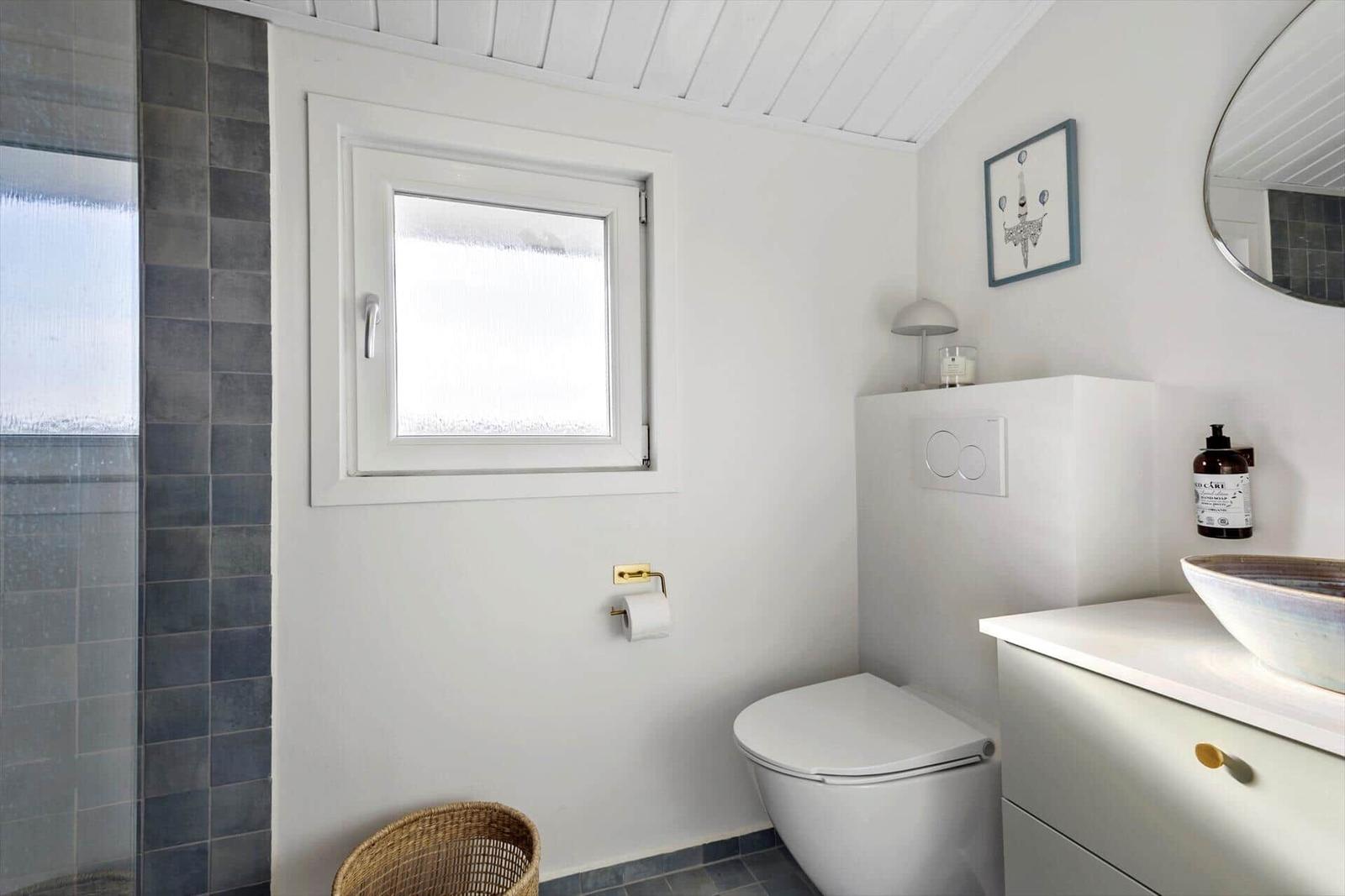 Bathroom with toilet, sink, and shower.