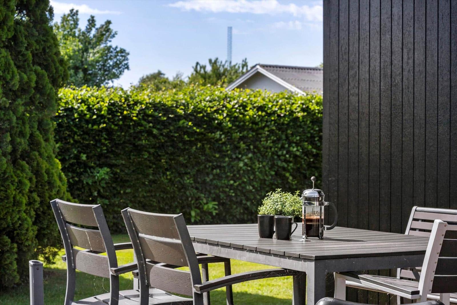 Outdoor area with table, chairs, and fresh coffee.