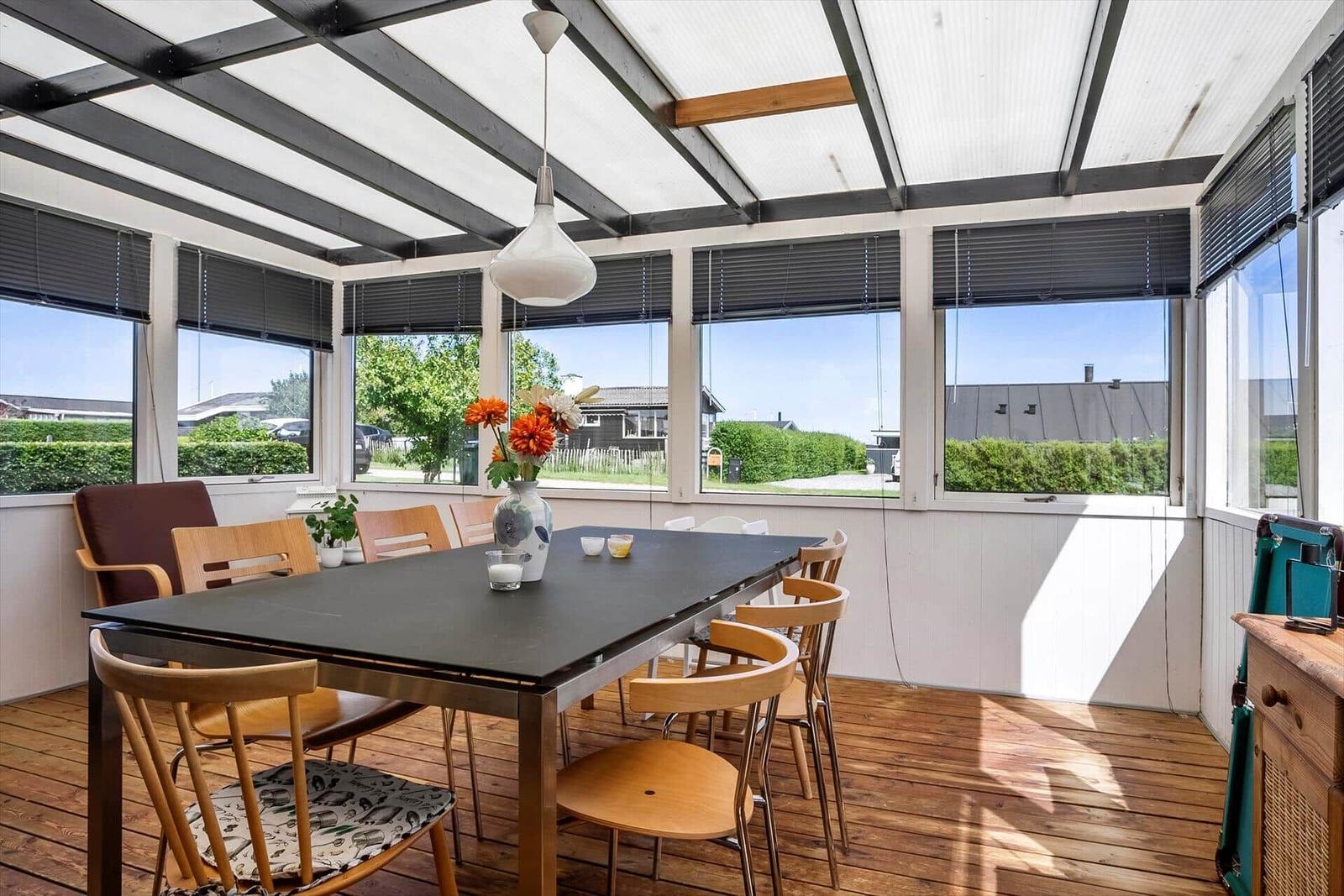 Dining area with table, chairs, and windows to the garden