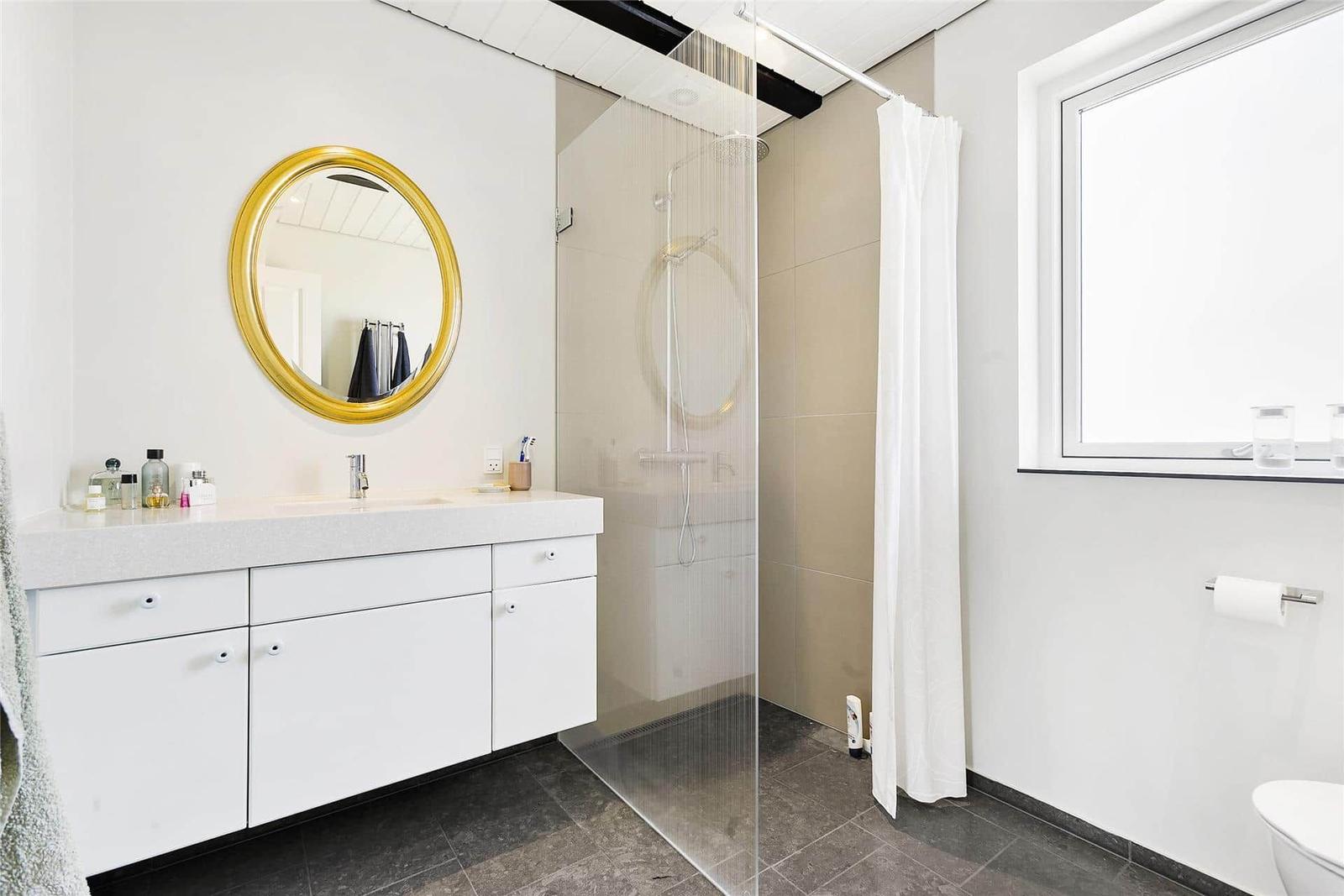 Bathroom with shower, sink and window.