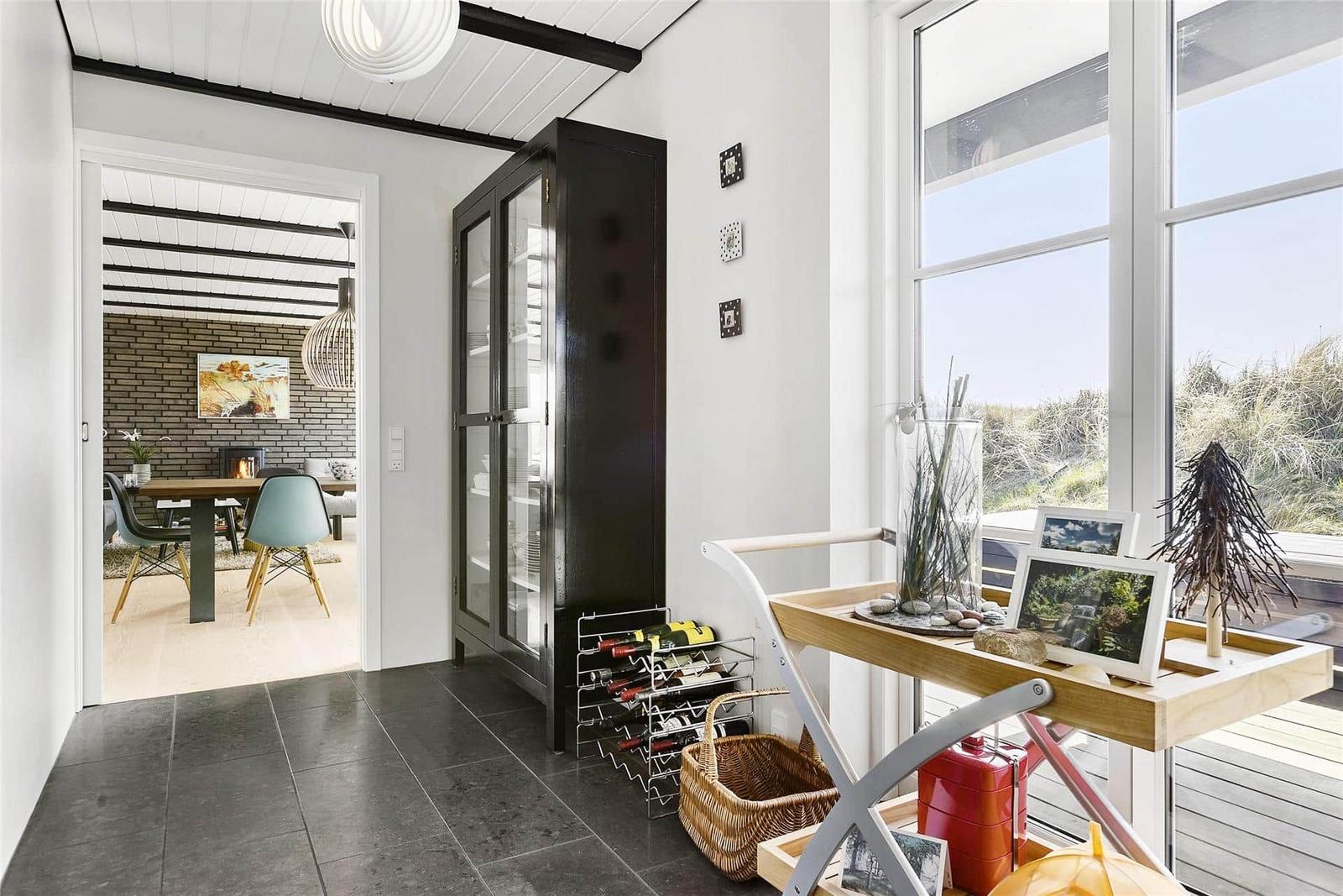 Entryway with glass cabinet, wine rack, and view of the terrace.