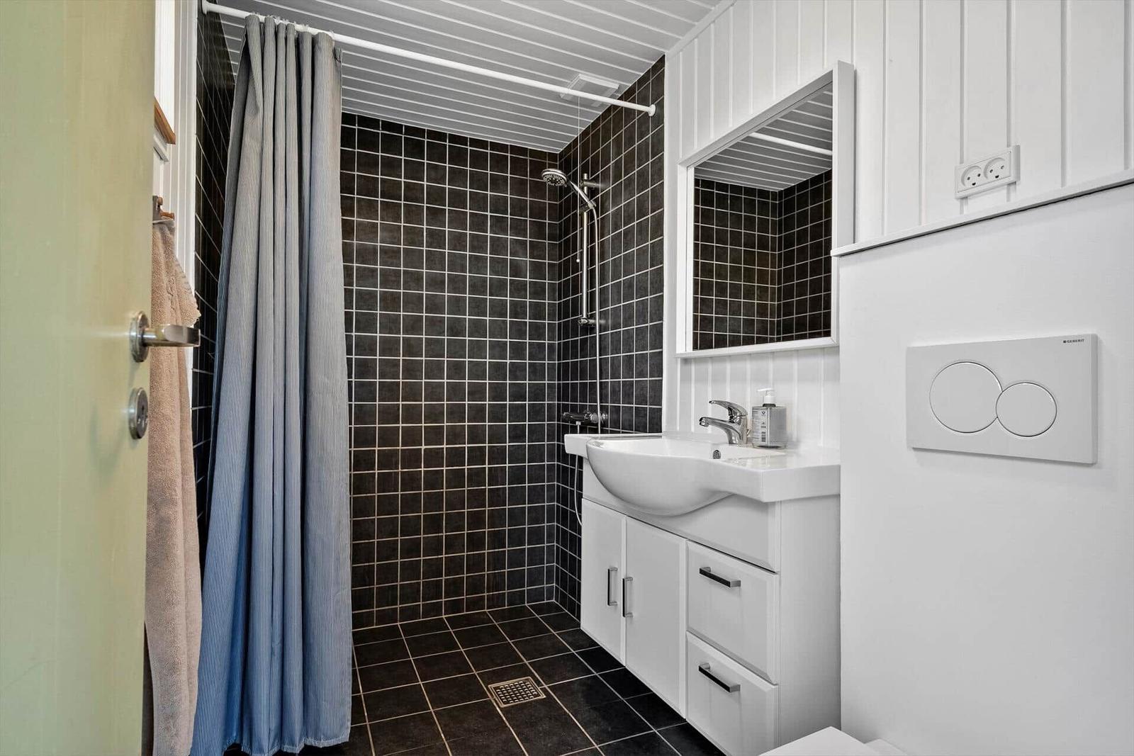 Badezimmer mit Dusche, Waschbecken und Toilette.