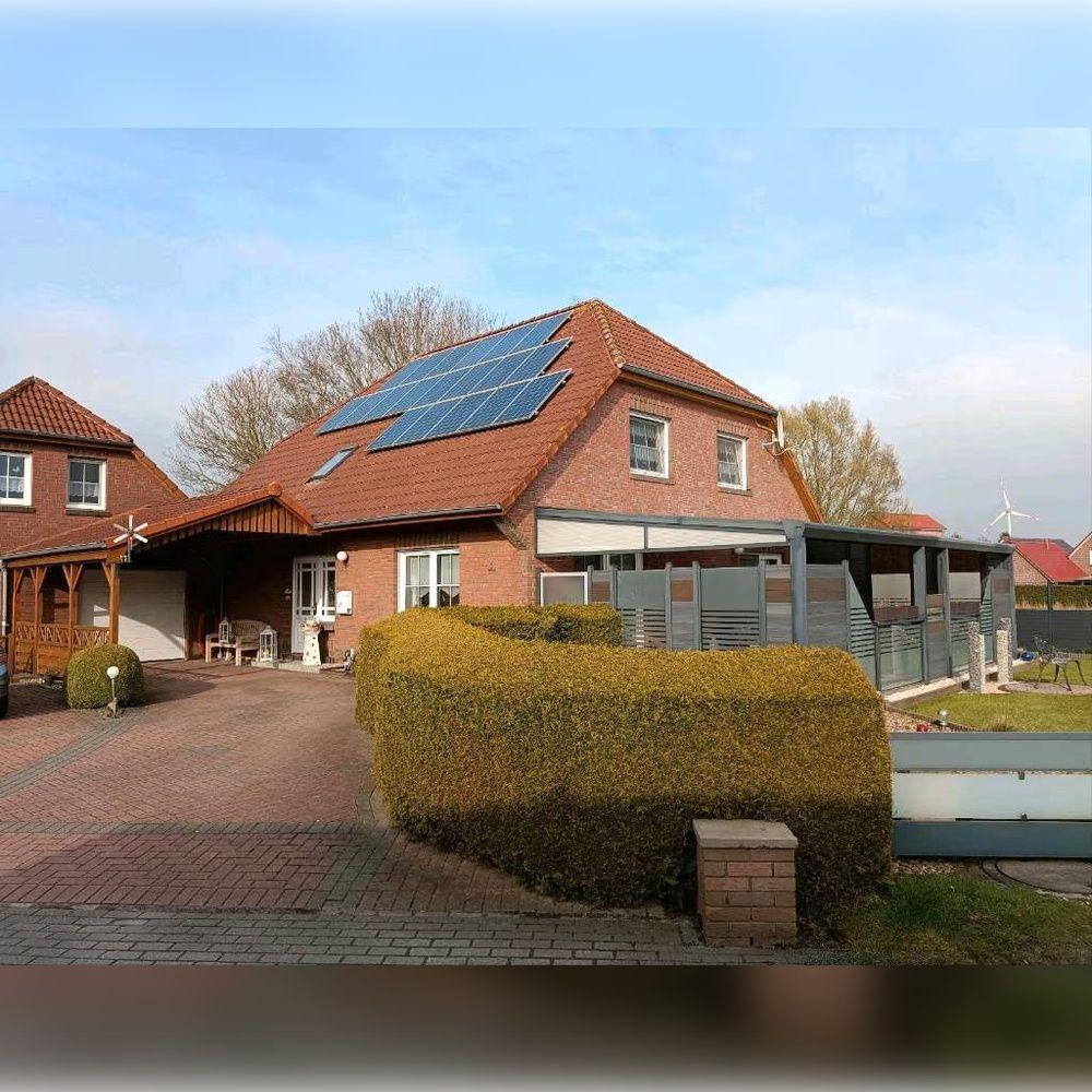 Haus mit Solaranlage, Terrasse und gepflegtem Gartenbereich.
