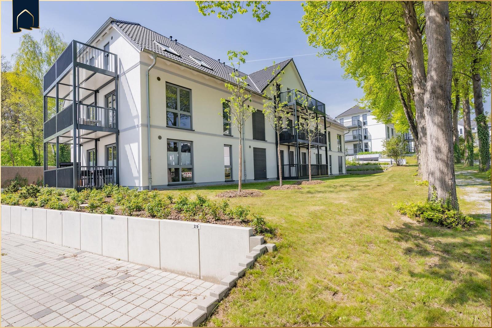 Moderne Wohnanlage mit Balkonen und grünem Außenbereich.