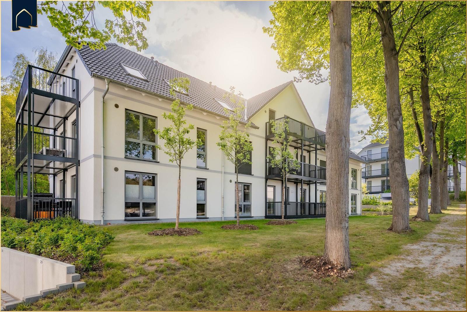 Moderne Wohnhaus mit Balkonen und Grünanlagen.