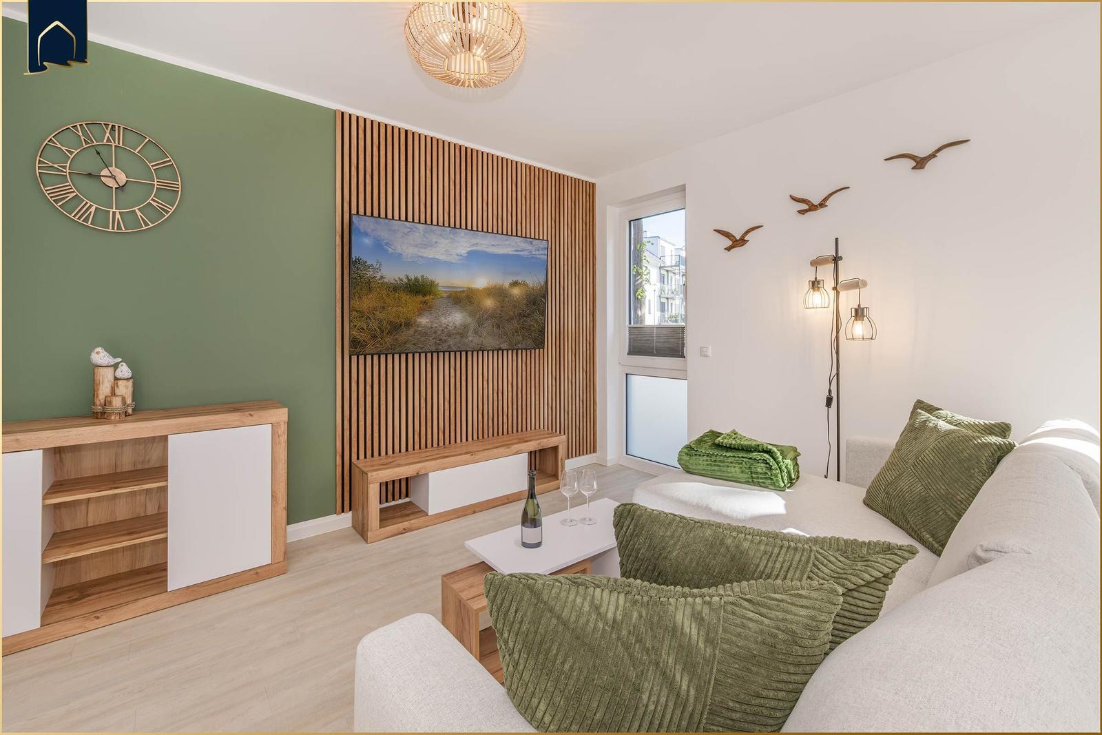 Wohnzimmer mit Sofa, Fernseher und Holzelementen an der Wand.