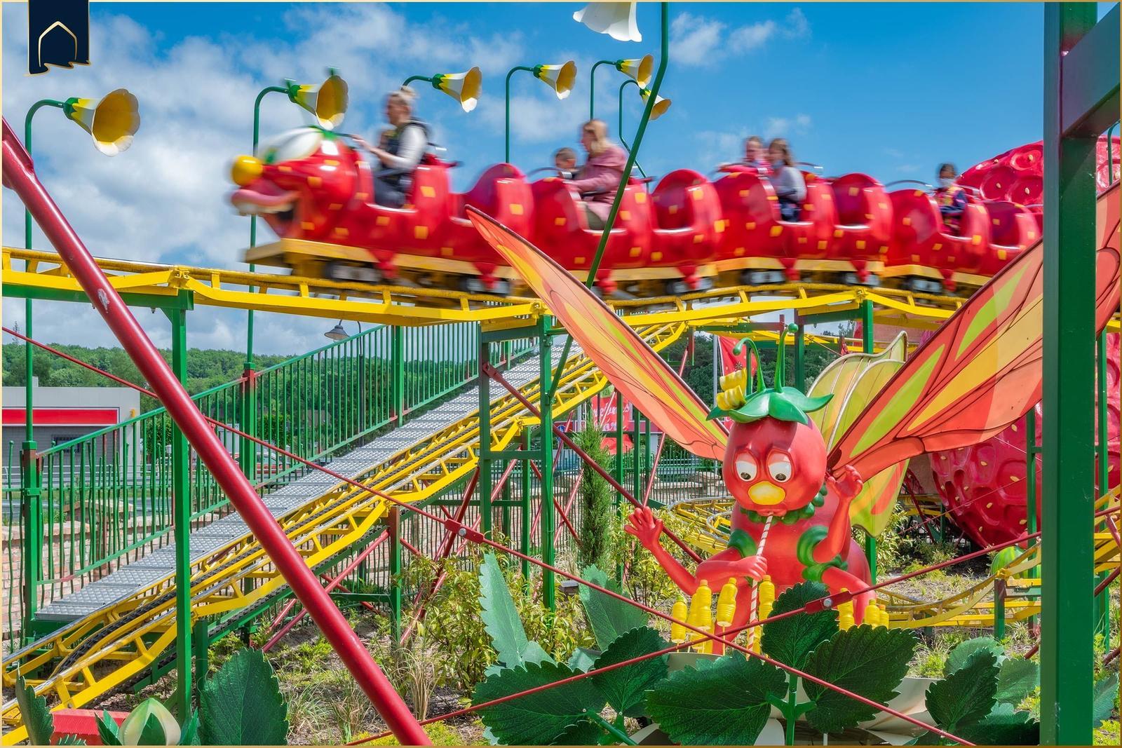 Rote Schmetterlings-Fahrt mit Kindern, große Erdbeere im Vordergrund.