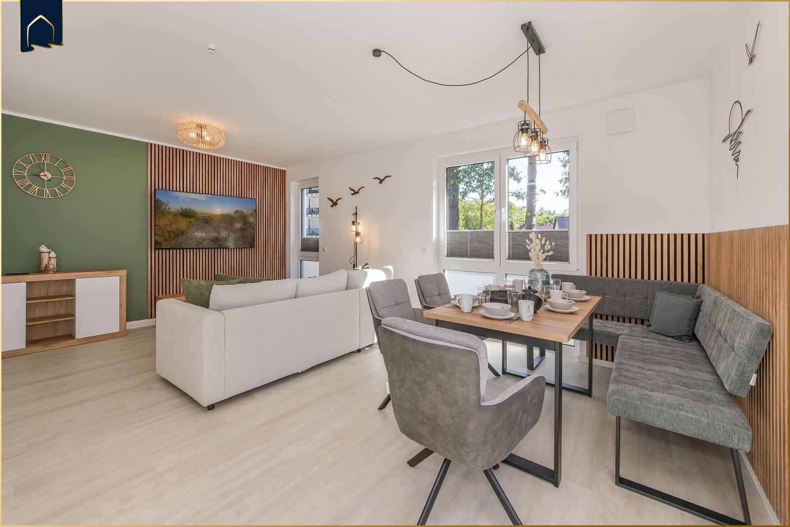 Wohn- und Essbereich mit Sofa, Esstisch und Fenster zur Außenseite.