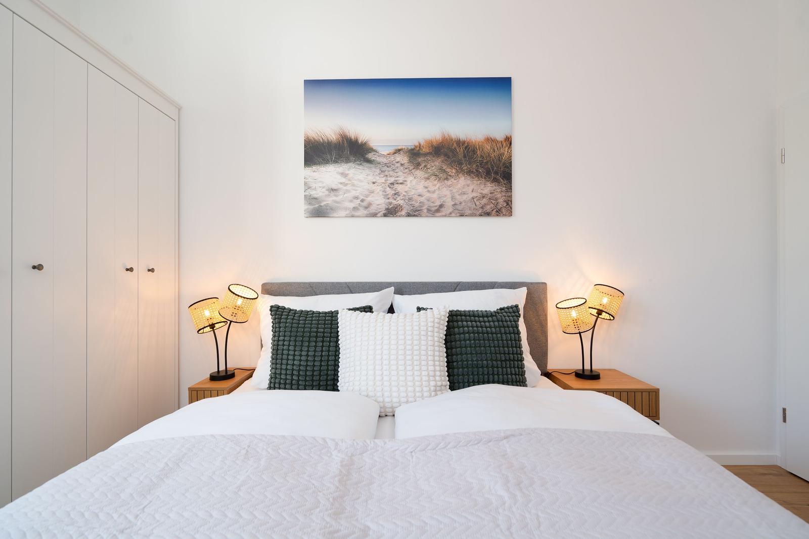 Schlafzimmer mit Bett, Nachttischen und Wandbild