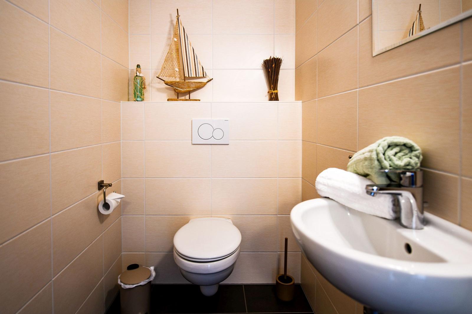 Badezimmer mit Toilette, Waschbecken und dekorativen Gegenständen.