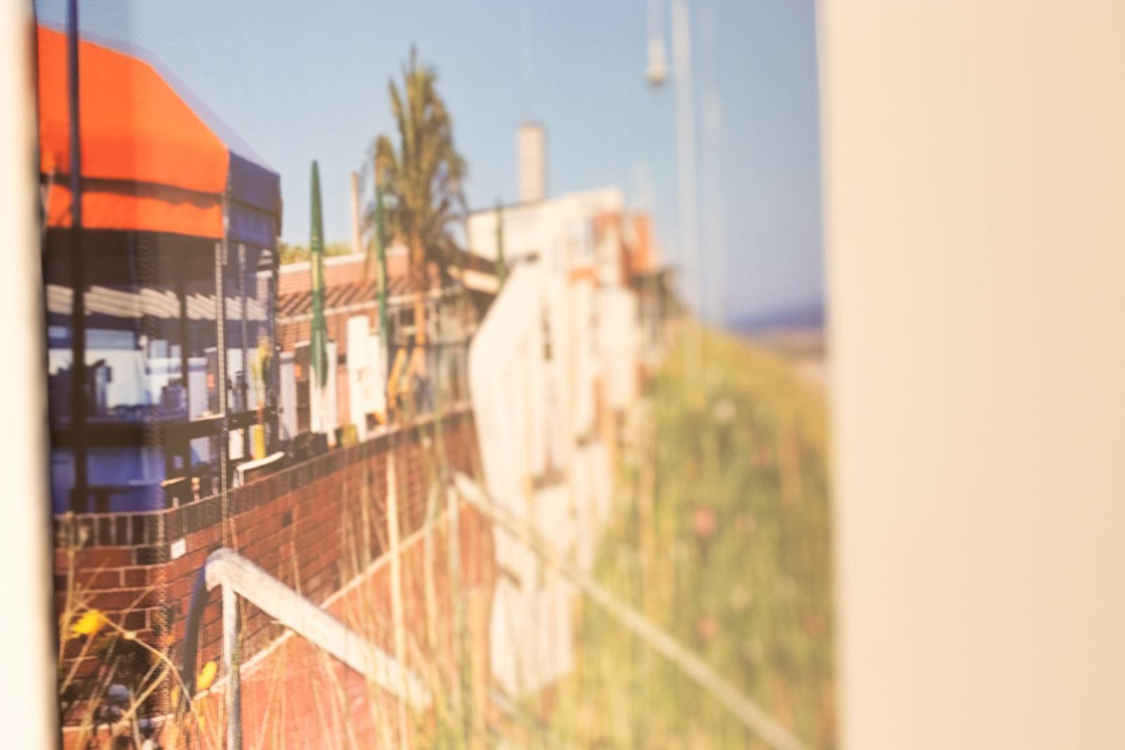 Fensterblick auf Terrasse mit Sonnenschutz und Palmen im Hintergrund.