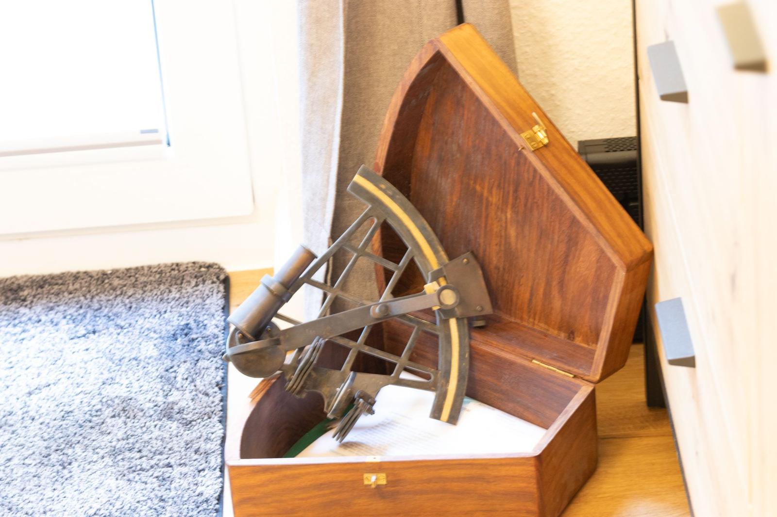 Antikmessinstrument in Holzkiste auf Boden