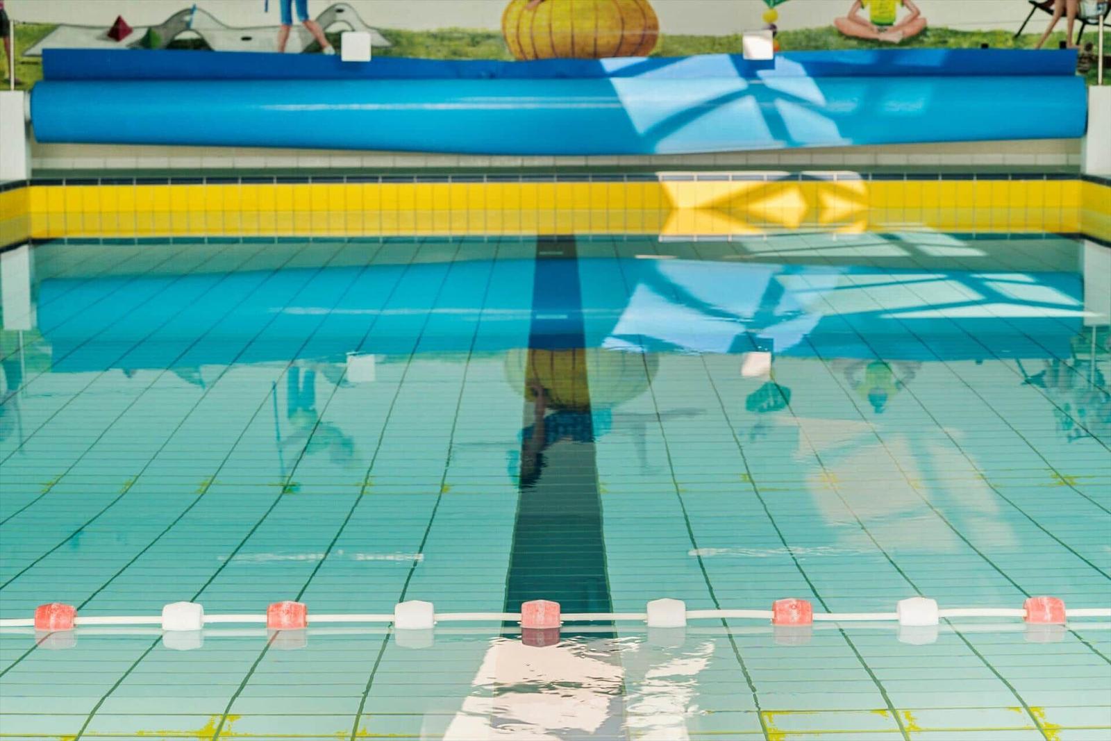 Indoor-Schwimmbad mit blauem Wasser und gelben Fliesen
