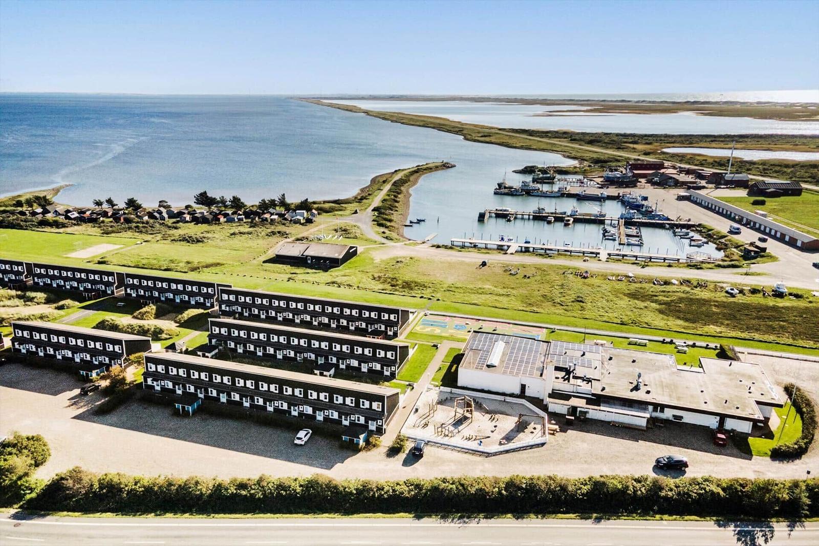 Strandnahe Ferienanlage mit Bootshafen und mehreren Gebäuden.