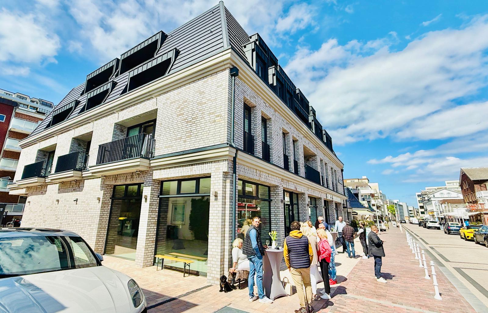 Moderne Villa mit Balkonen und Glasfassade an belebter Straße