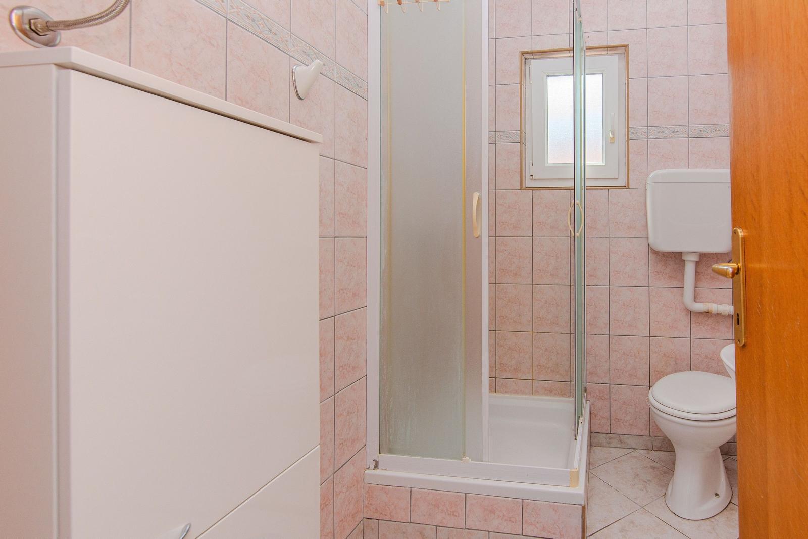 Bathroom with shower, toilet, and sink.