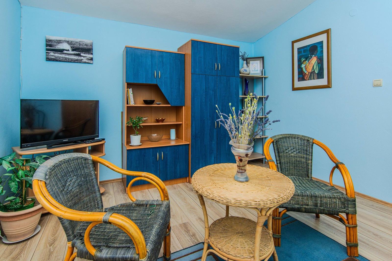 A living room with blue walls, a round table, and two chairs.