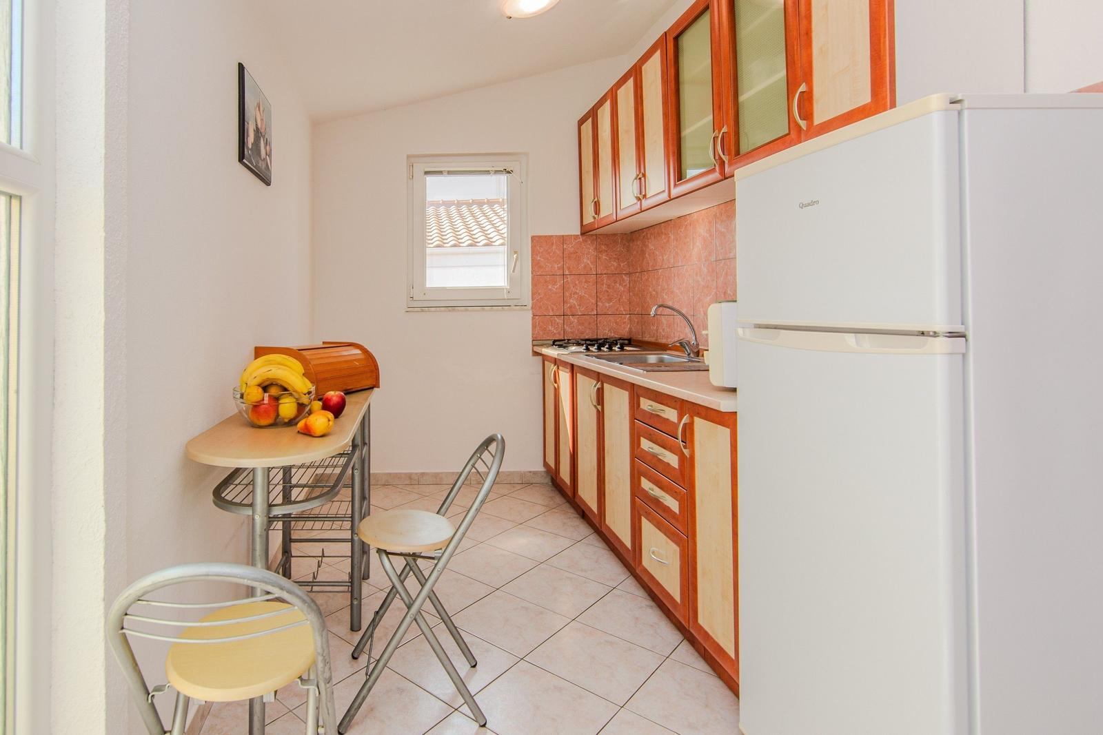 Kitchen with dining table, fridge, and window.