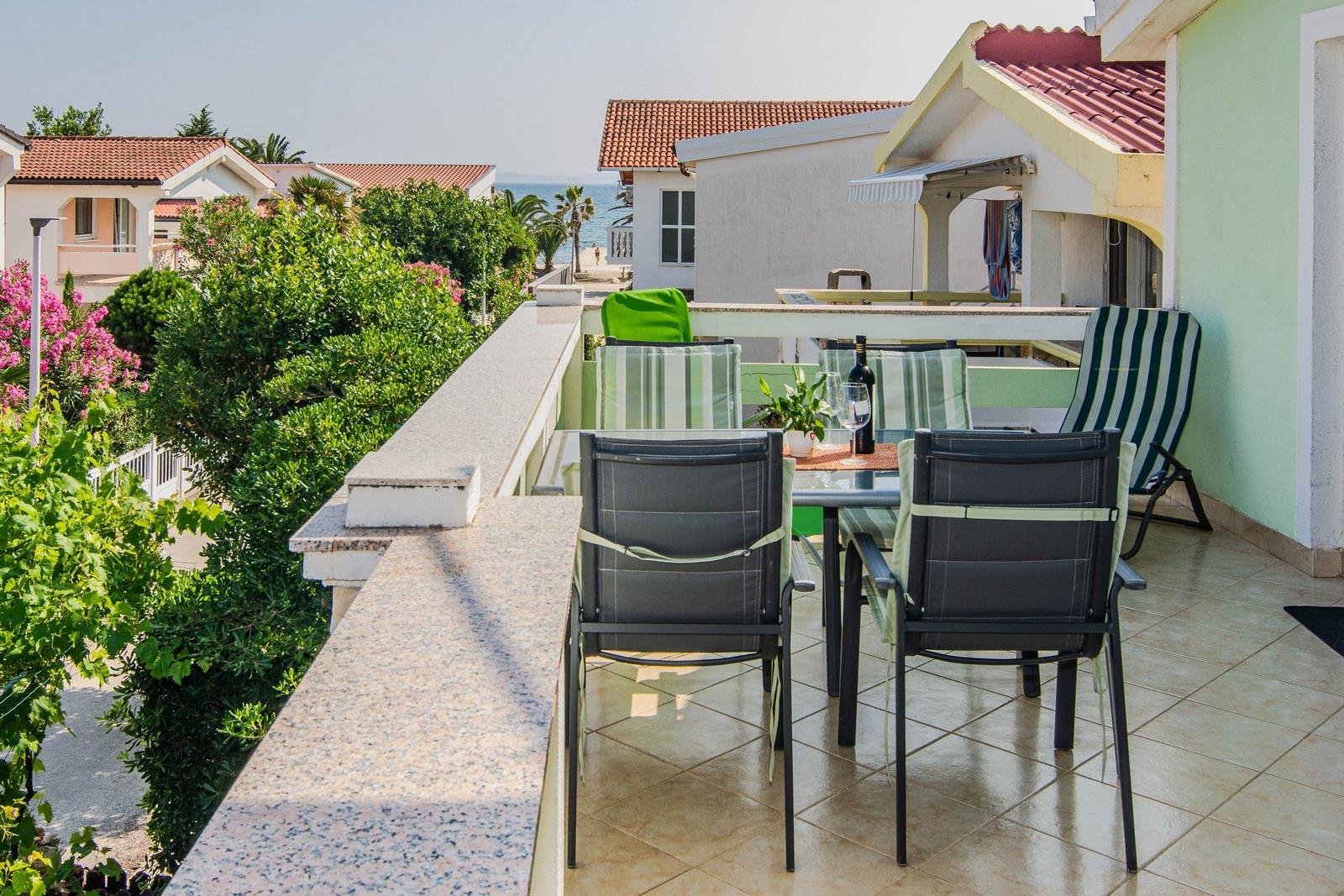Terrace with table, chairs, and sea view.