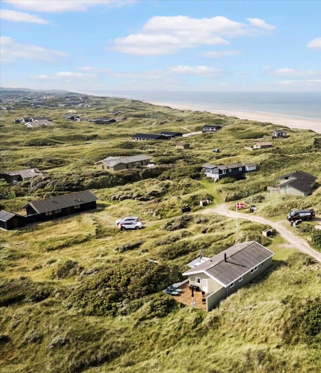 Hütten auf grünen Dünen mit Blick auf das Meer