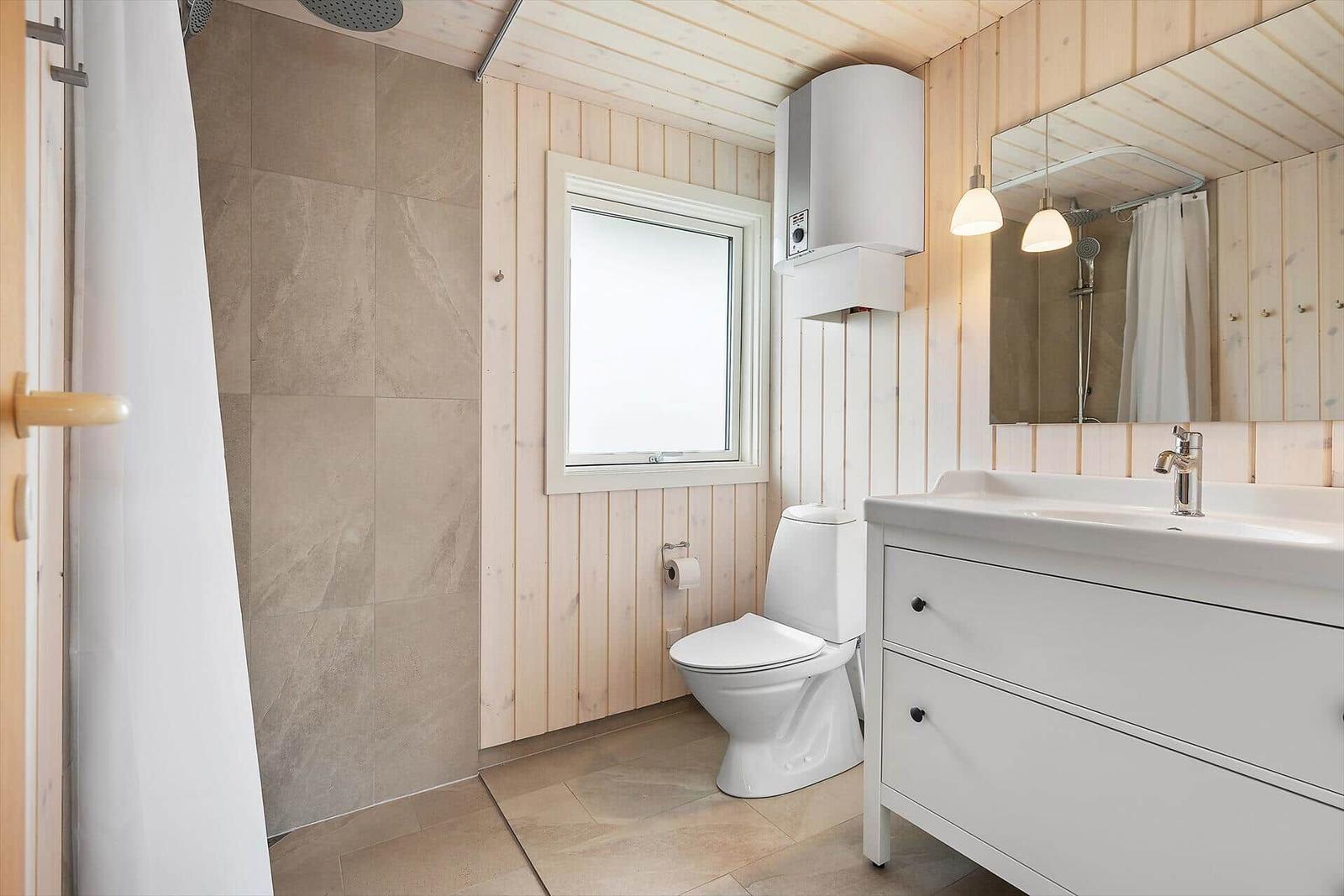 Badezimmer mit Dusche, Toilette und Waschbecken.