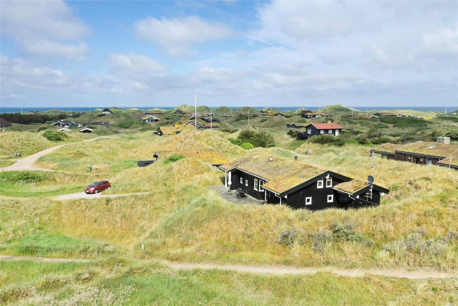 Haus auf Dünen mit Blick auf Meer und Wanderweg