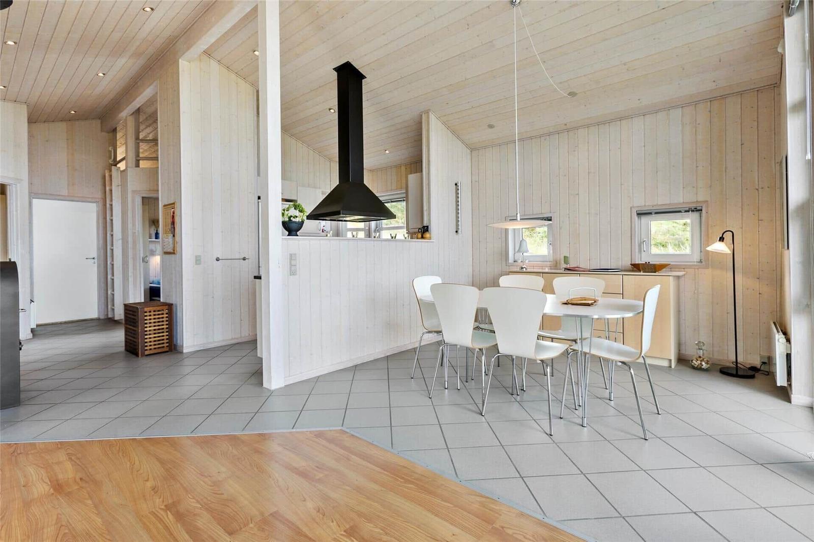 Küche und Essbereich mit Holzwand und weißem Tisch