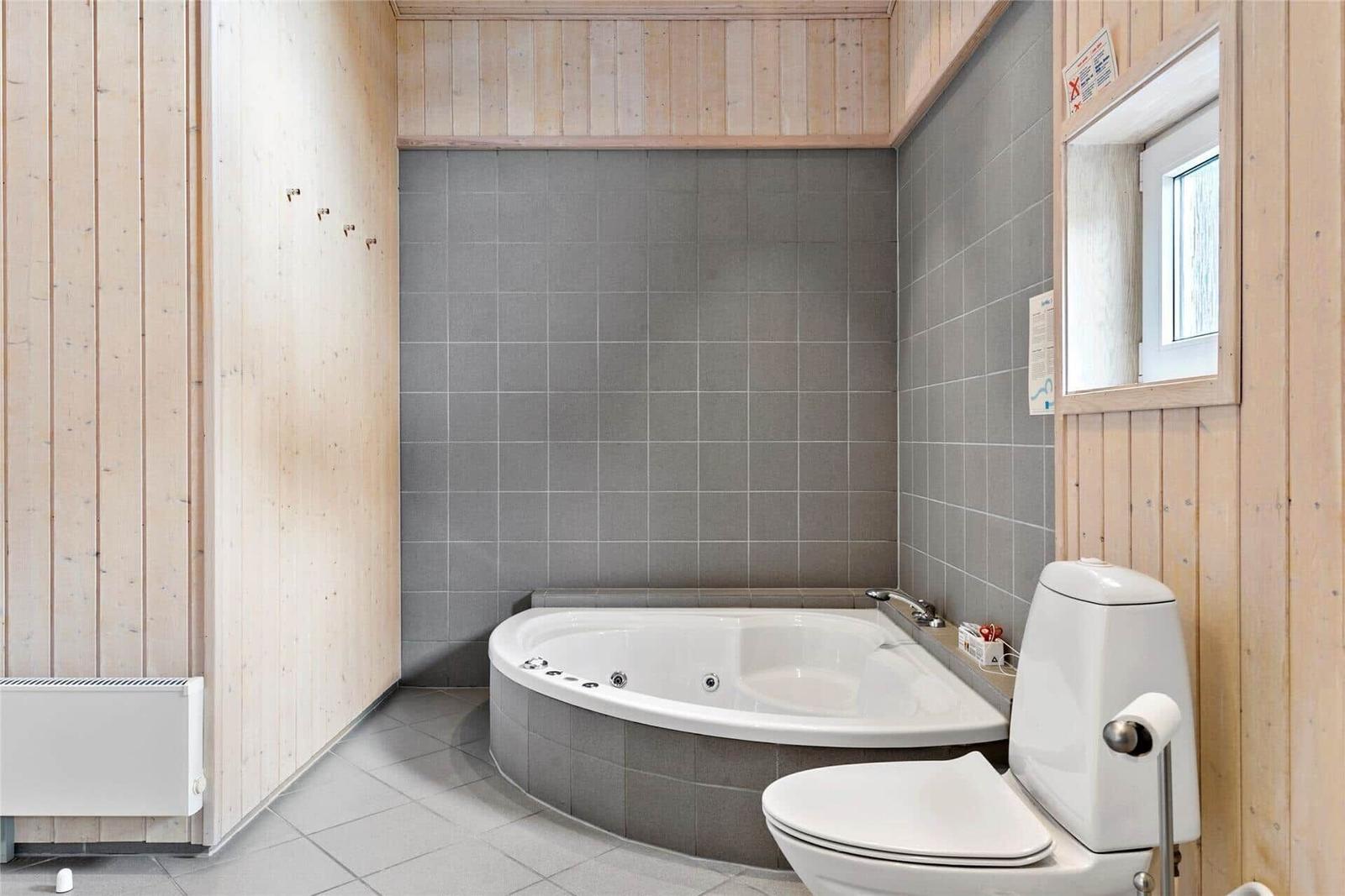 Bad mit Whirlpool, Toilette und Fenster