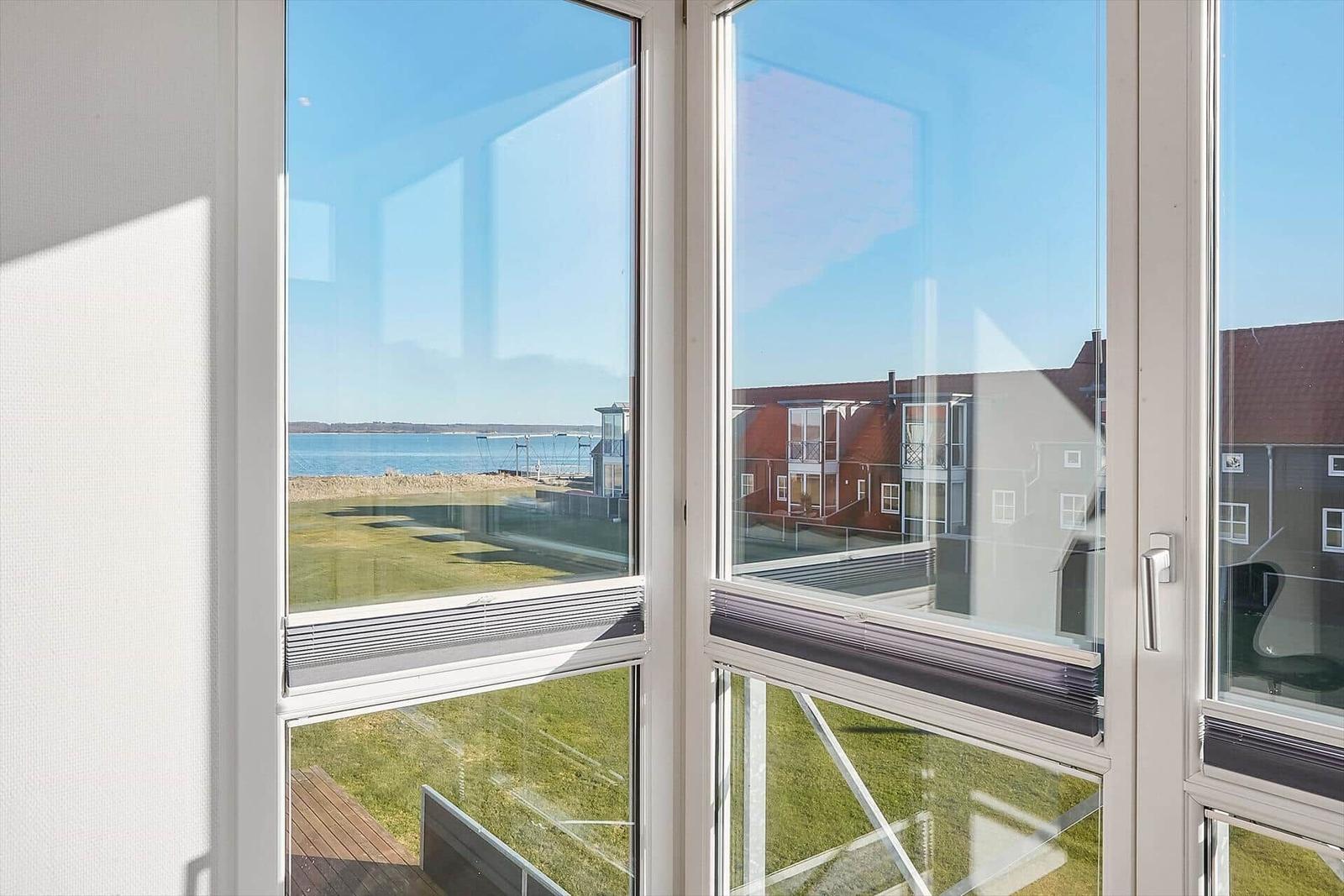 Durch die Fenster ist ein Blick auf den See und angrenzende Gebäude zu sehen.