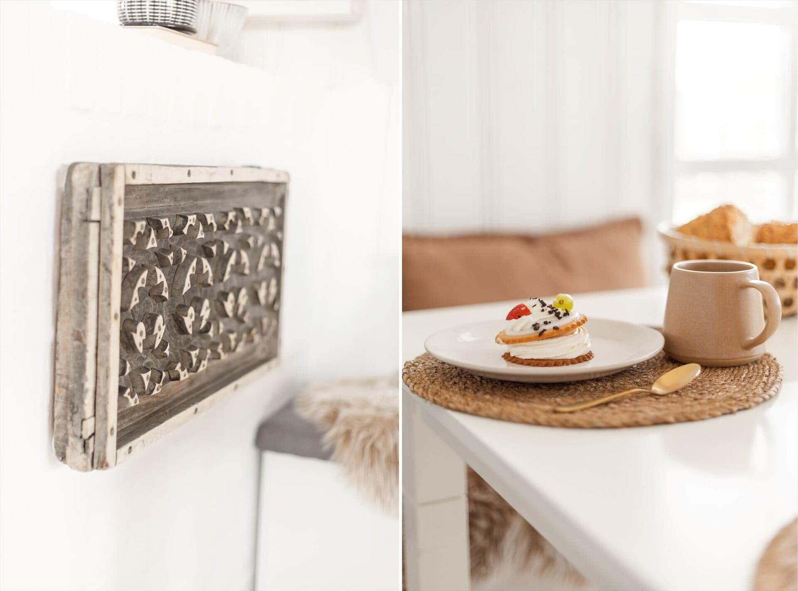 Wanddekoration mit Holzschnitt und Tisch mit Kuchen und Tasse.