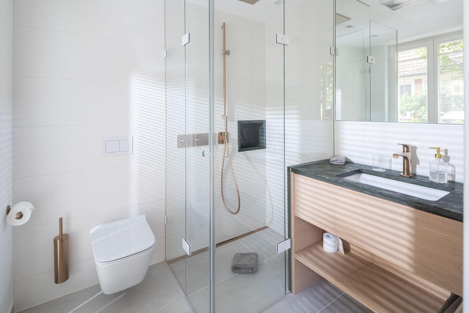 Moderne Badezimmer mit Dusche, Waschbecken und Toilette.