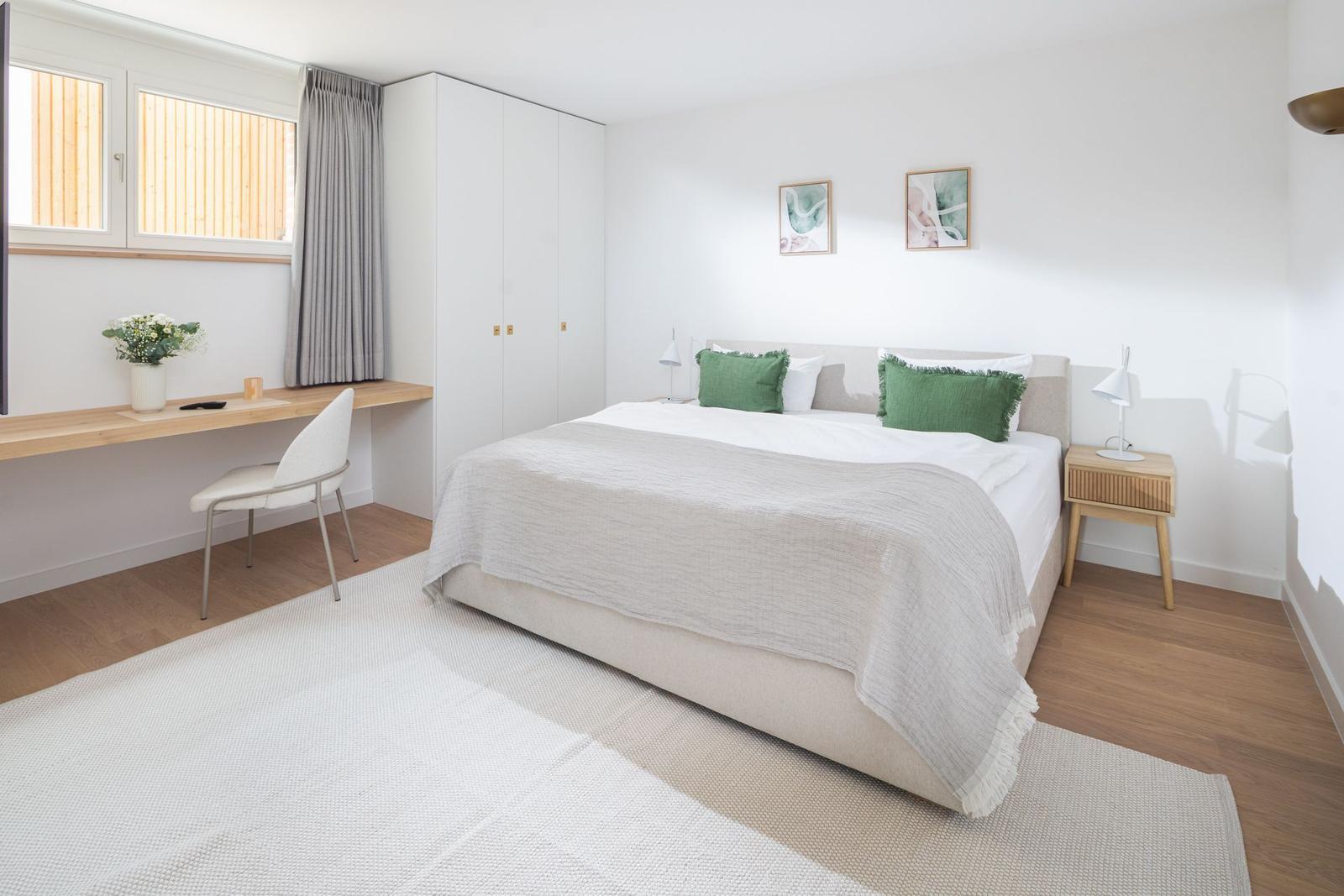 Schlafzimmer mit Bett, Schreibtisch und Kleiderschrank