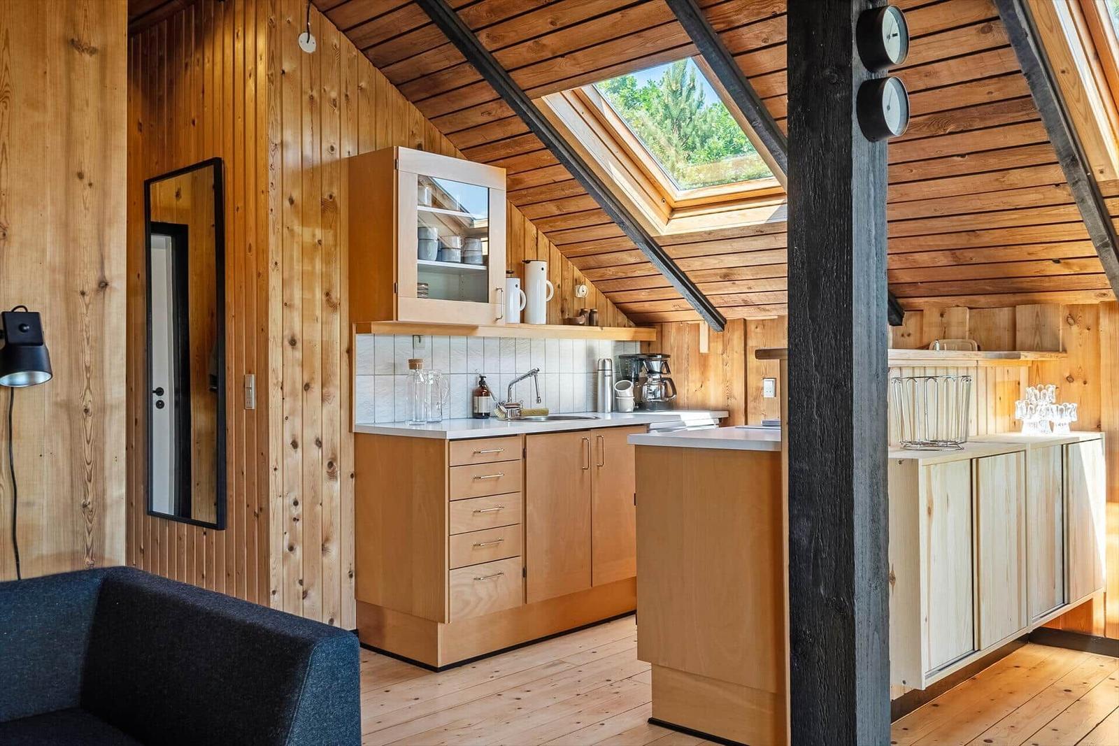 Küche mit Holzwänden, Dachfenster und Arbeitsplatte