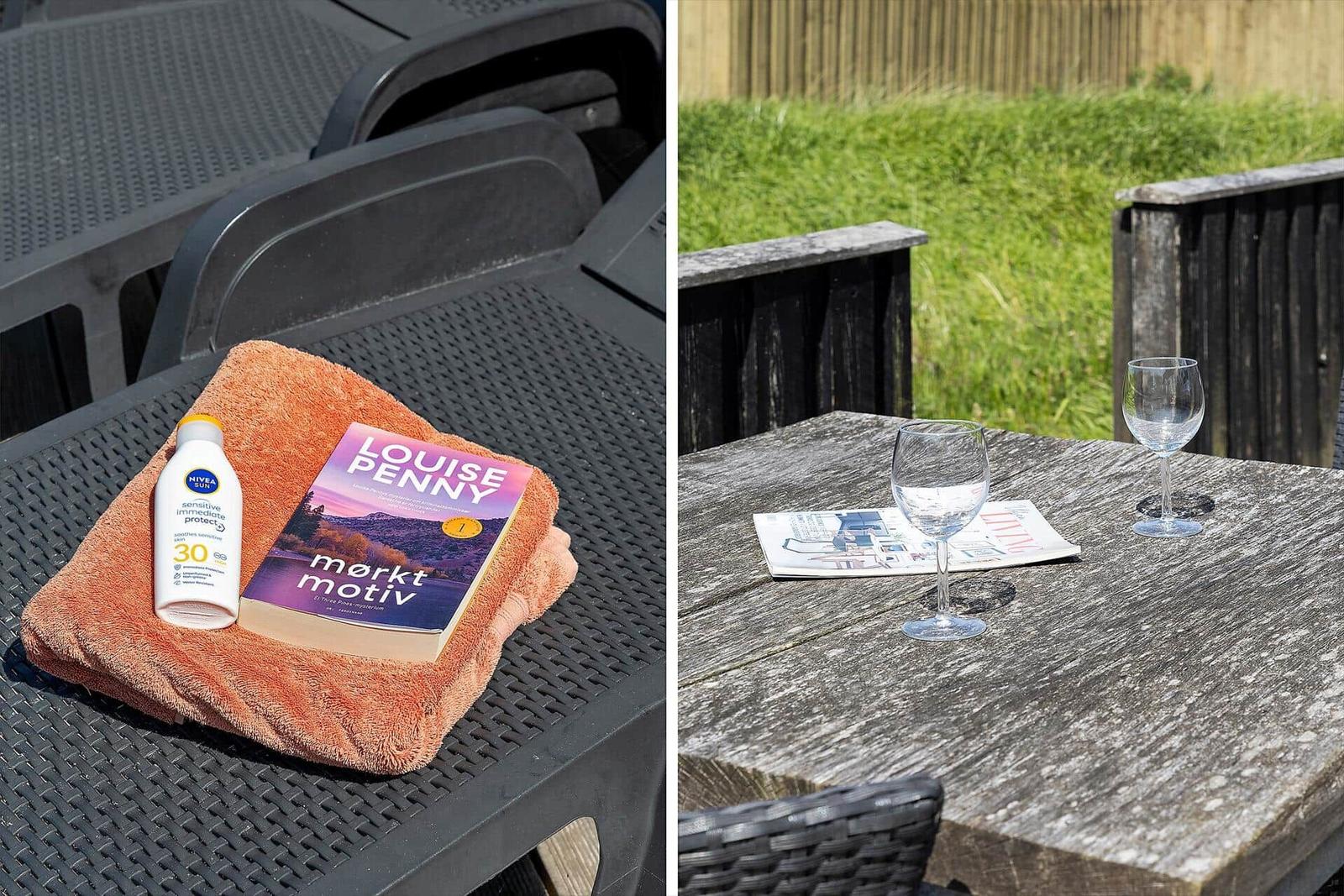 Außentisch mit Buch und Sonnenschutzmittel. Holztisch mit Gläsern und Zeitschrift.