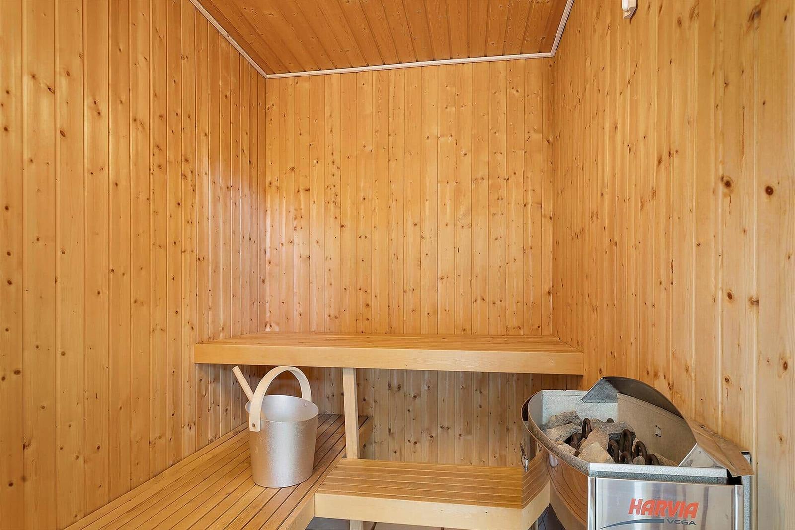 Sauna mit Holzwand, Sitzbank und Harvia Heizung.