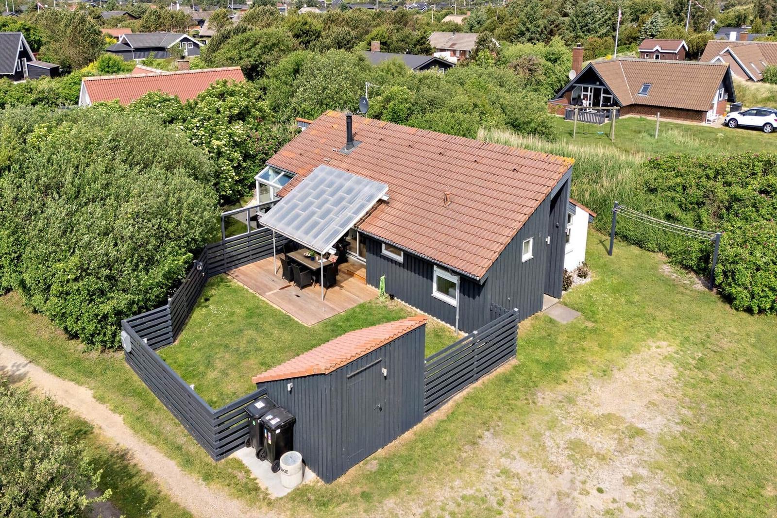 Ein Haus mit Terrasse, Garten und Solarium. Umgeben von Grün und Nachbarhäusern.