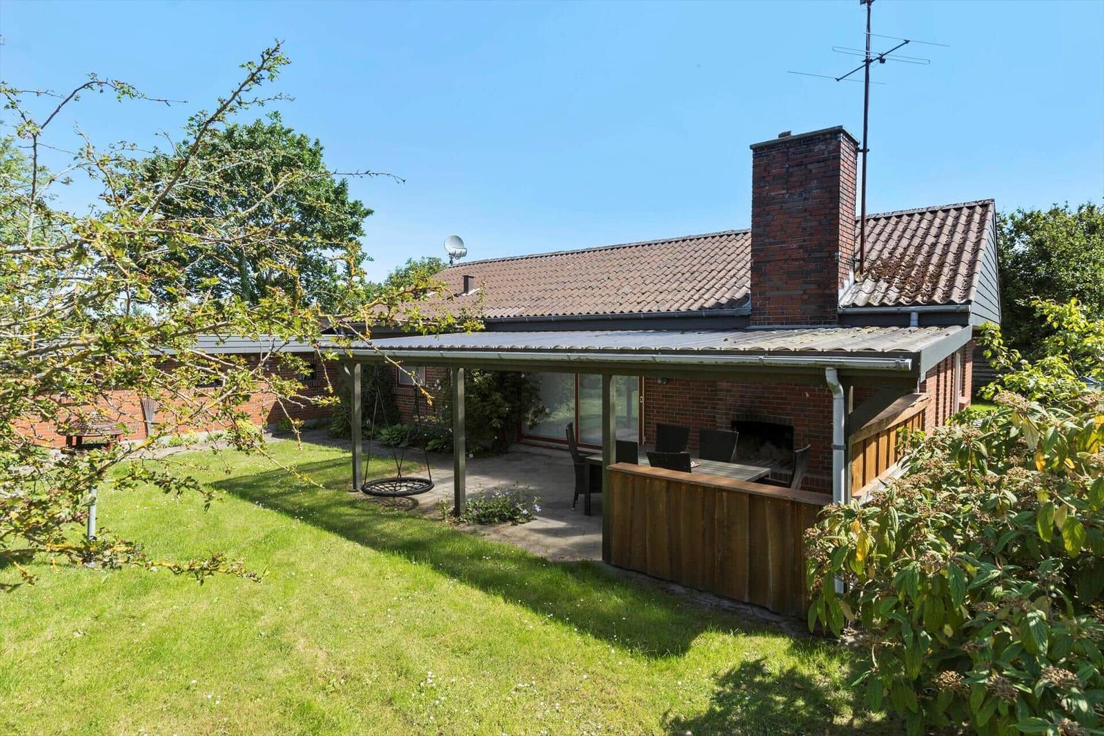 House with terrace, grill and swing in the garden.
