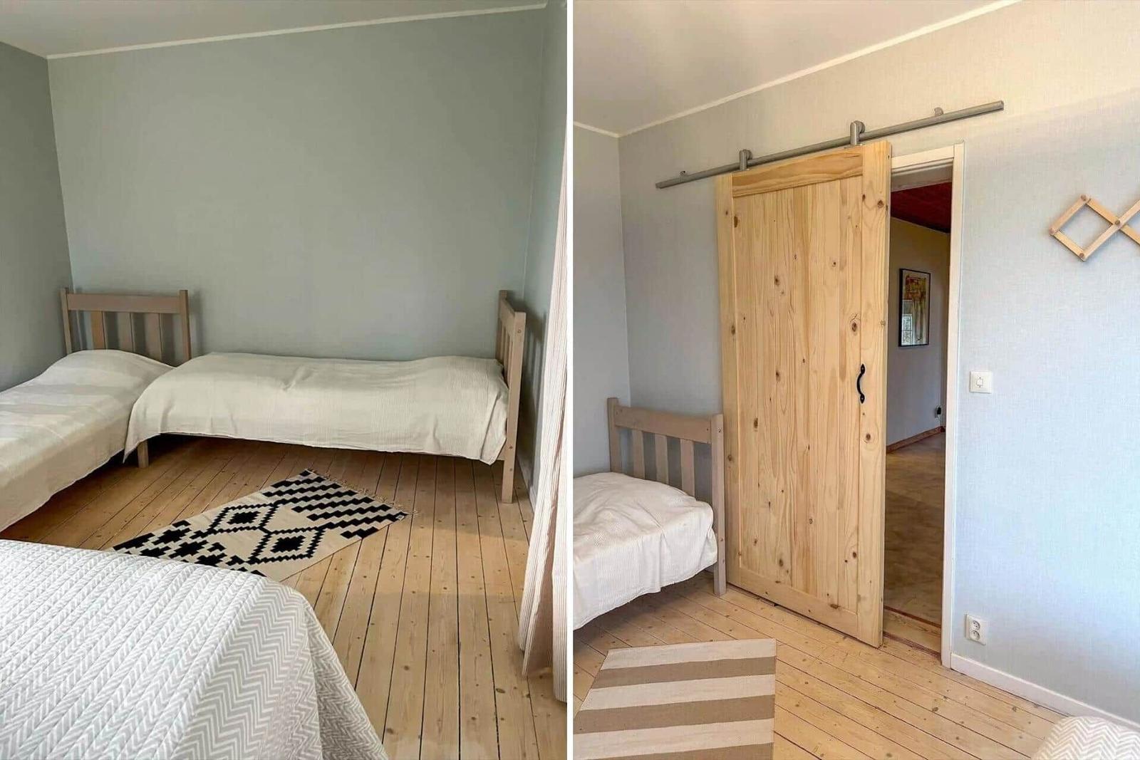 Zimmer mit zwei Betten und Holzboden. Schiebetür führt in einen Flur.