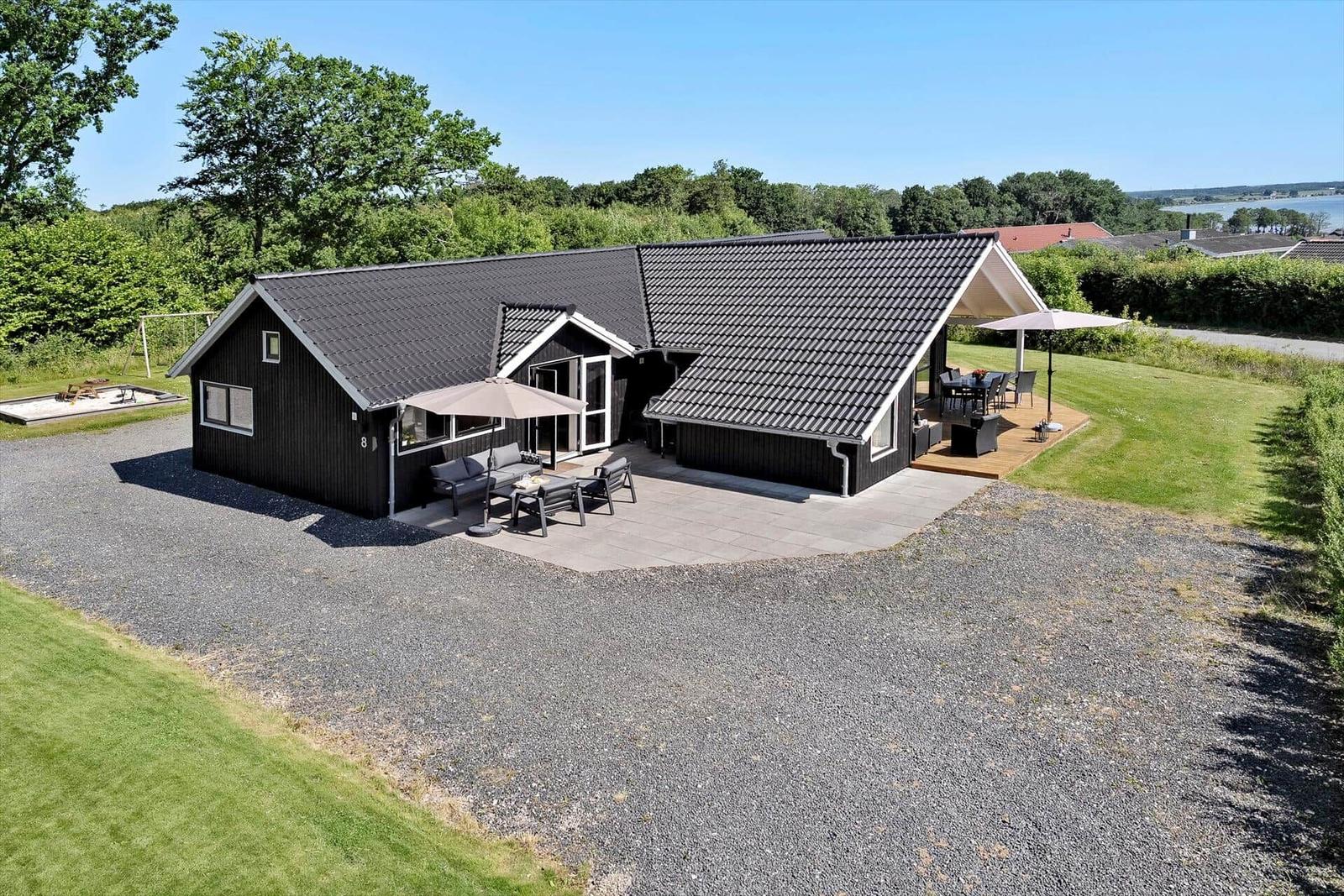 Black house with terrace and garden. Outdoor area with seating.