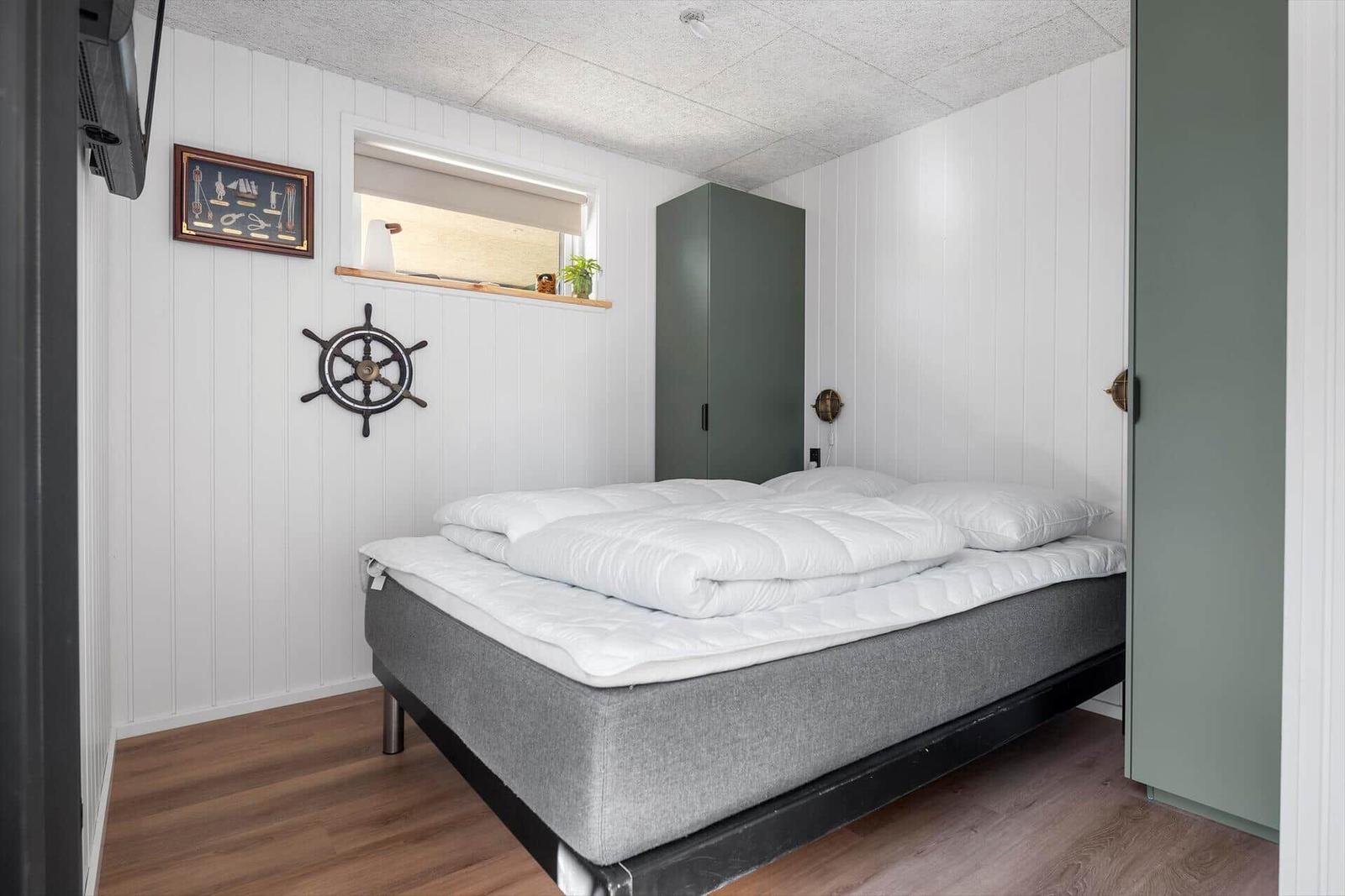 Schlafzimmer mit Bett, Kleiderschrank und Fenster