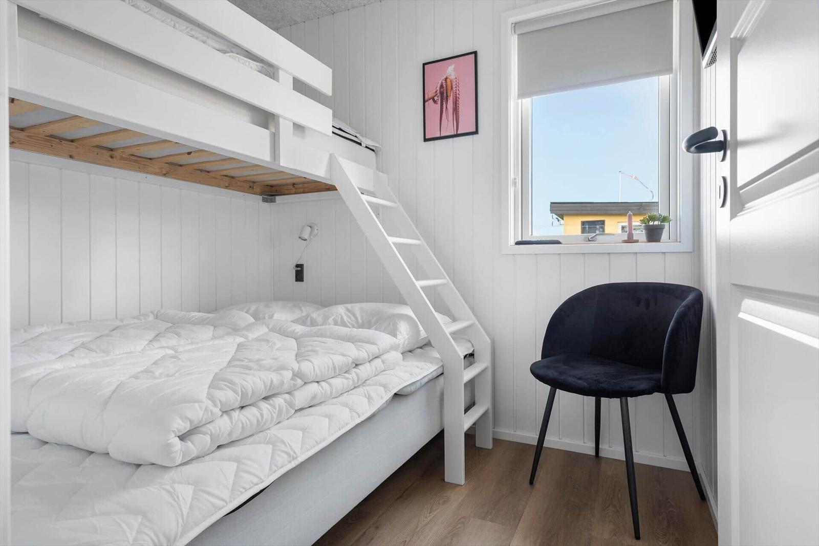 Zimmer mit Doppelbett, Kletterstuhl und Fenster mit Blick.