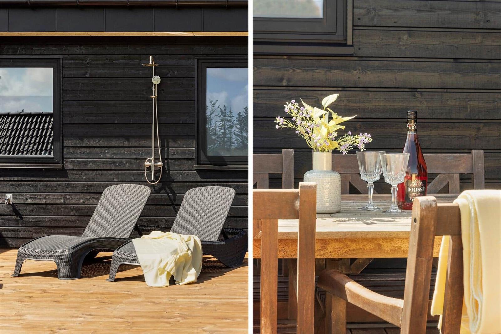 Außenbereich mit Dusche und Liegestühlen. Holztisch mit Blumen und Flasche.