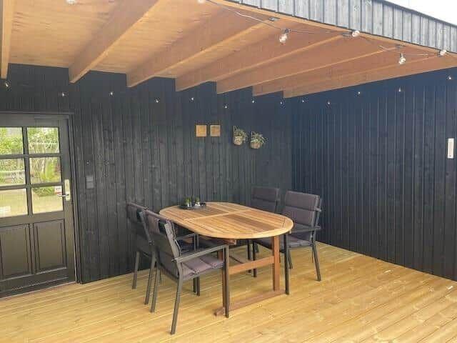 Terrasse mit Holztisch und Stühlen unter Dach