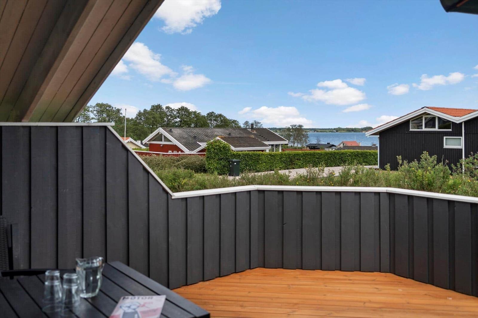 Deck with wooden floor and view of water and houses