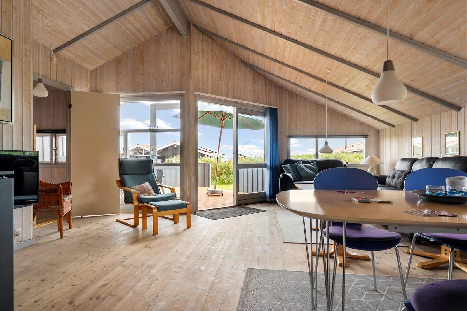 Living area with dining table, seating, and view to the terrace.