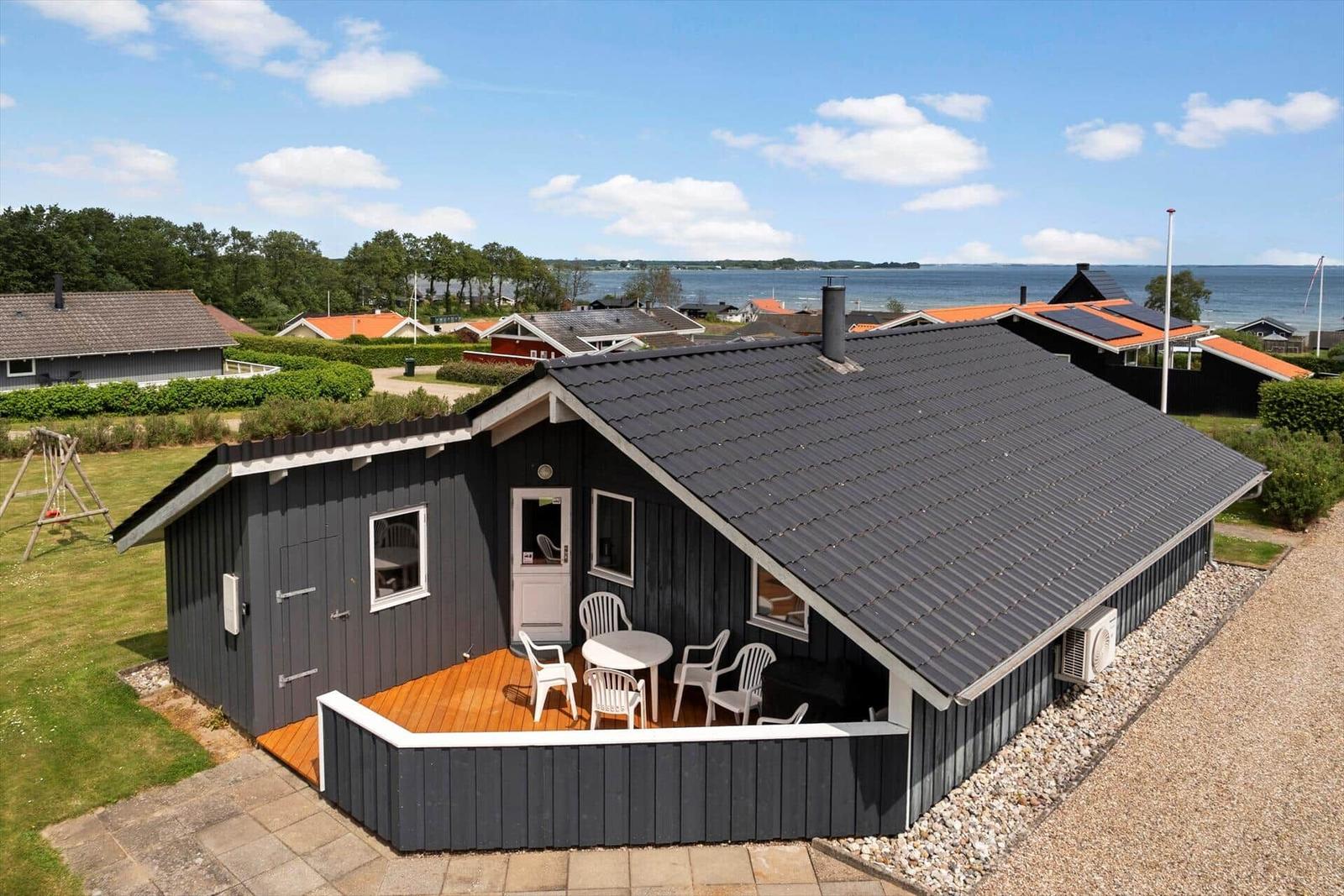Wooden house with terrace, garden, and sea view.